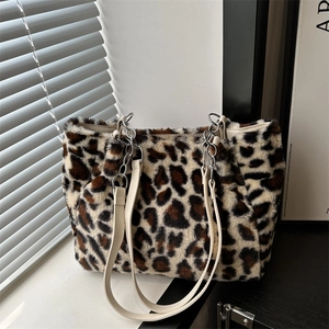 Sac fourre-tout en peluche léopard avec bandoulière à chaîne près d'une fenêtre moderne