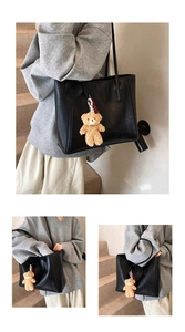 Detail of black leather tote bag with a cute teddy bear charm for daily commuting