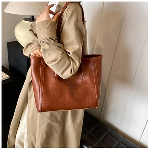 Close-up of caramel brown leather tote bag with vintage texture and spacious design