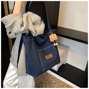 Large dark blue denim tote bag with leather label and cute plush charm on shoulder strap