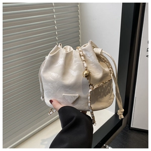 Detail of white oil-wax leather bucket bag with gold chain and drawstring closure