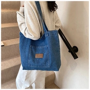 Classic large-capacity dark blue denim tote bag with front pocket and leather patch label