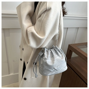 Detail of light blue marble bucket bag with silver chain strap and drawstring closure