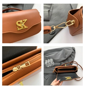 Details einer karamellbraunen Ledertasche mit goldenem Logo-Verschluss und Innenfächern