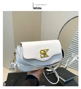 Details der weißen Leder-Schultertasche mit goldener SK-Metallschnalle und feiner Naht