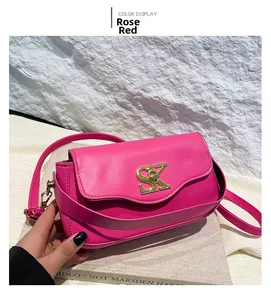 Detailansicht einer rosenroten matten Lederhandtasche mit goldener SK-Metallschließe