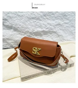 Detail einer braunen Umhängetasche aus Leder mit goldener SK-Schnalle und Premium-Struktur