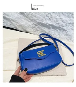 Detailansicht der blauen Ledertasche mit goldenem SK-Metalllogo und verstellbarem Gurt
