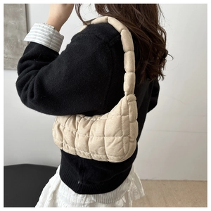 Gros plan du sac beige matelassé à bulles avec texture rembourrée et large bandoulière