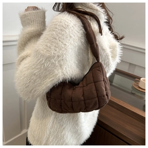 Détail du sac à bandoulière matelassé marron foncé avec coutures carrées et texture douce