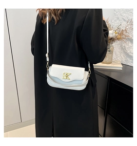 Detailansicht der weißen Leder-Umhängetasche mit goldenem SK-Logo und schmalem Gurt