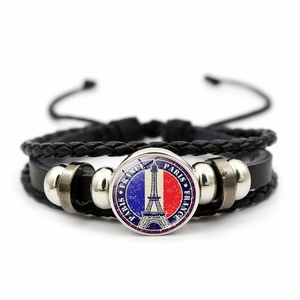 Dettaglio del bracciale multistrato in pelle con ciondolo in vetro della Torre Eiffel