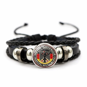 Dettaglio macro del bracciale in pelle intrecciata con emblema della bandiera tedesca