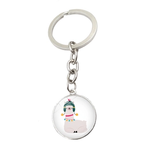 Detail of silver alpaca keychain with glass dome pendant featuring a cute cartoon design