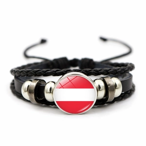 Primer plano detallado de una pulsera de cuero trenzado con el cabujón de la bandera austríaca