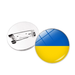 Détail du badge rond drapeau Ukraine avec dôme en résine et fermoir papillon en métal
