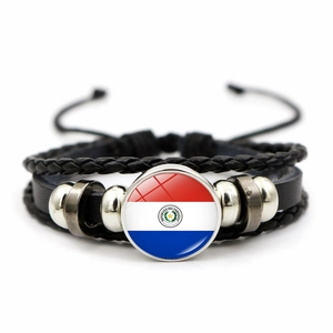 Close-up of leather bracelet with Paraguay flag emblem and braided black rope detail