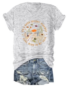 Dettaglio di t-shirt vintage con grafica desert e shorts in denim consumato a terra