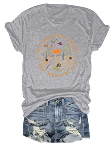 T-shirt grigia con stampa desertica e pantaloncini in denim consumati distesi