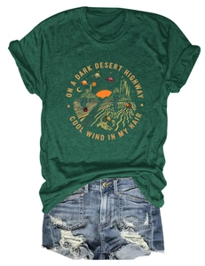 Dettaglio flat lay di t-shirt verde scuro con stampa deserto e pantaloncini denim