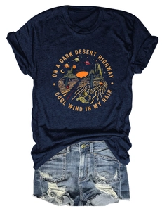 Vista piatta di t-shirt blu scuro con grafica desertica e pantaloncini denim chiari