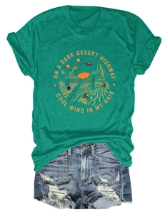Dettaglio della t-shirt verde con stampa grafica vintage di strada del deserto e teschio