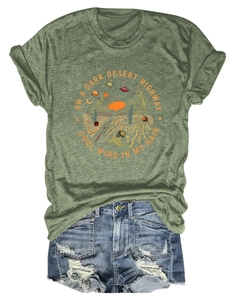 Dettaglio della stampa desertica vintage su t-shirt verde scuro e pantaloncini denim