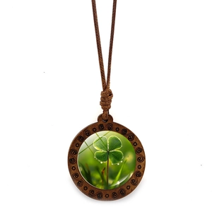 Macro view of four-leaf clover pendant with wood frame and brown woven rope