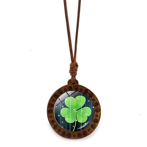 Macro shot of retro wooden clover pendant with glass cabochon on brown cord