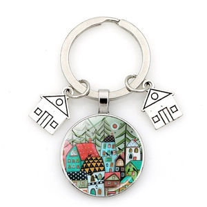 Artistic keychain with starry sky house pendant and silver metal charms on white backdrop