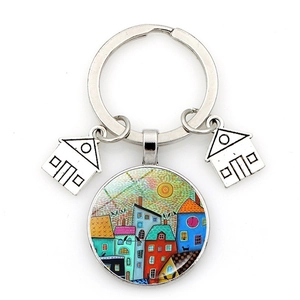 Artistic keychain featuring a colorful town painting and silver house charms on white
