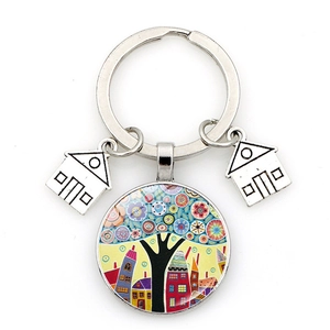 Macro shot of silver keychain featuring artistic colorful tree and house house pendants