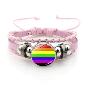 Dettaglio del bracciale in pelle intrecciata rosa con ciondolo bandiera arcobaleno e perline