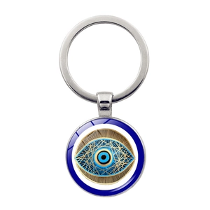 Macro detail of Turkish evil eye charm with golden geometric rays on silver keychain