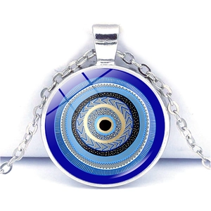 Vue macro d'un pendentif œil bleu en verre avec cadre argenté sur fond blanc