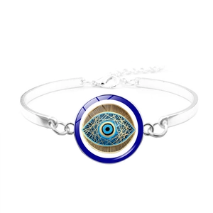 Macro shot of silver evil eye bangle featuring blue and white concentric enamel detail