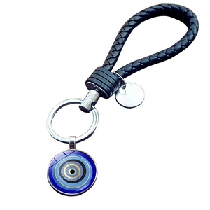 Macro view of Turkish evil eye charm with black braided leather strap and silver ring