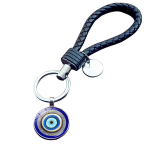 Detail of woven leather cord keychain with Turkish evil eye charm and silver-tone metal ring