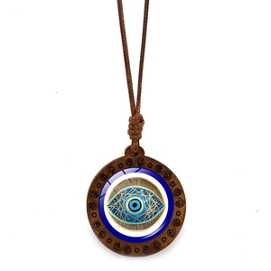 Macro shot of evil eye wood pendant with vintage cloud carving and brown wax cord