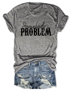Mise à plat d'un t-shirt gris avec texte Somebody's Problem et short en jean déchiré