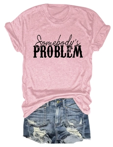 Détail d'un t-shirt rose en coton avec texte noir et mini short en jean bleu