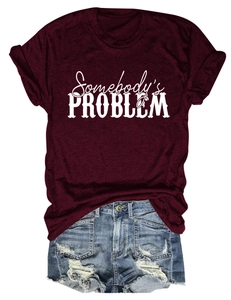 Détail du t-shirt bordeaux Somebody's Problem avec un short en jean délavé