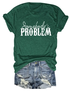 Détail de l'imprimé Somebody's Problem sur t-shirt vert et short en jean déchiré