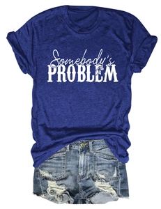 Détail du slogan Somebody's Problem sur un t-shirt bleu foncé avec un short en jean