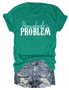 Détail du t-shirt vert Somebody's Problem assorti à un short en jean usé et vintage