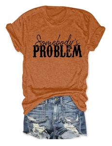 Détail du t-shirt orange caramel avec imprimé Somebody's Problem et short en jean