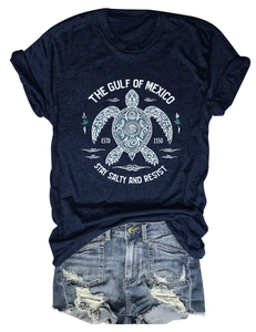 Détail d'un t-shirt en coton bleu marine avec graphique de tortue de mer et texte du Golfe