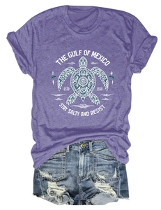 Détail d'un t-shirt violet avec imprimé tortue du Golfe du Mexique et short en jean bleu