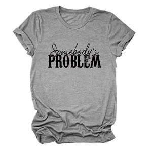 Gros plan du slogan Somebody's Problem sur t-shirt gris à col rond et manches retroussées