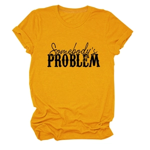 Détail du t-shirt jaune moutarde avec l'imprimé Somebody's Problem en noir